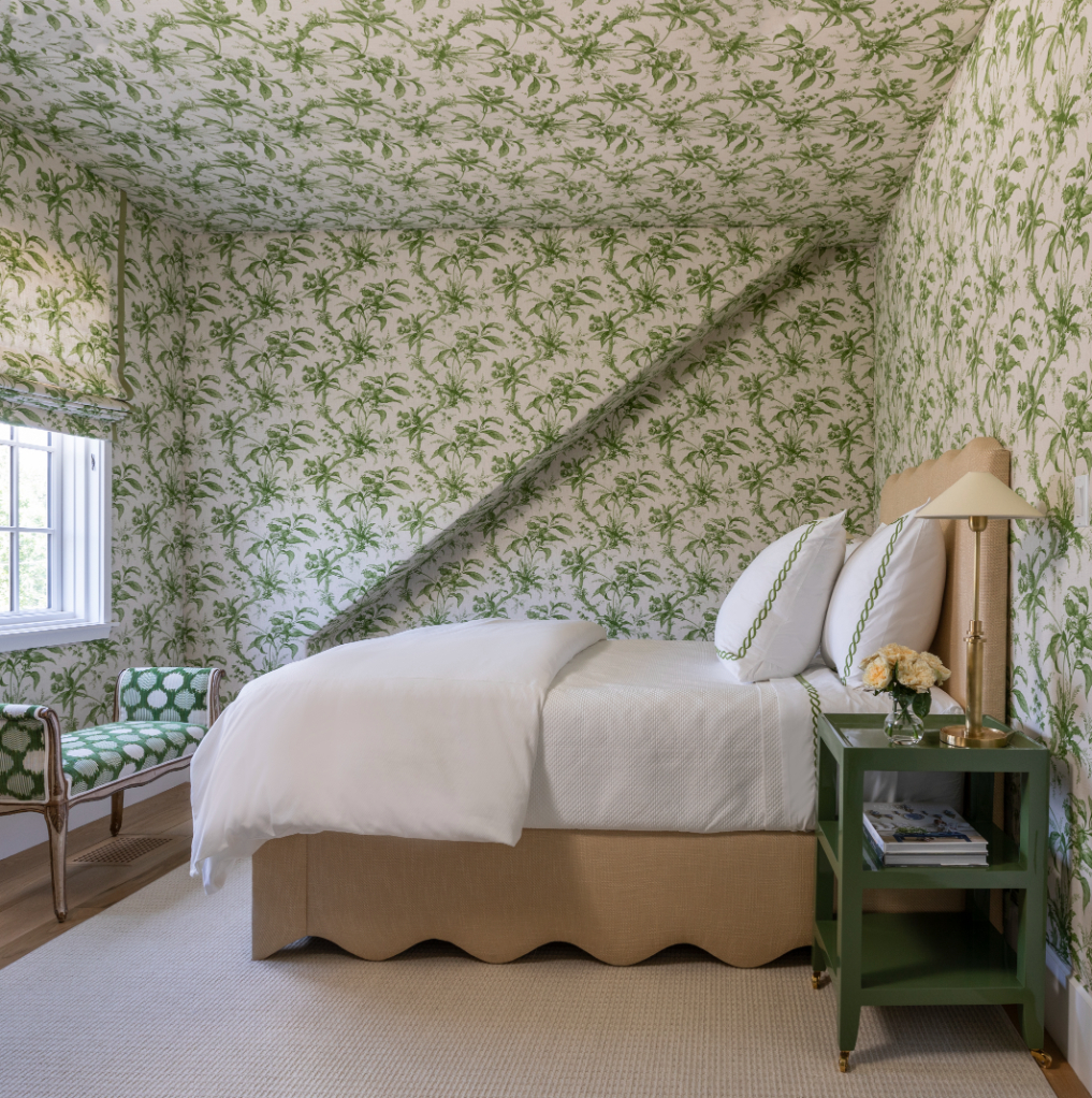 Existing fabric walls in the guest room were kept as-is. (“Who doesn’t love a floor to ceiling upholstered room?” Epley says.) The Joseph Company created the custom bed and bedside table; the client’s own bench was reupholstered in Schumacher’s Cirque Velvet. JULIE SOEFER