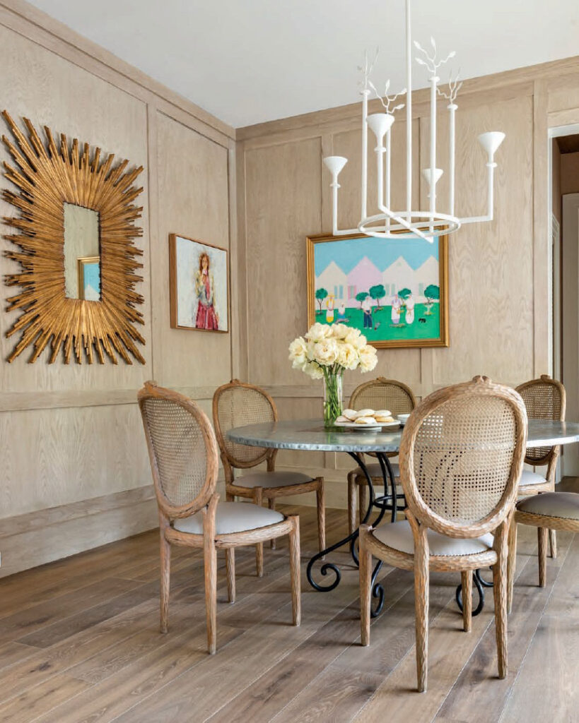 Luxe Interiors + Design Houston - Starting Fresh - White oak appears on the breakfast room floors and paneled walls, from which hang a verdant painting by Jim Hill and a work by Bibbi Anderson from Anarte. The plaster Vincennes chandelier by Bourgeois Boheme Atelier was the final piece selected for the home.