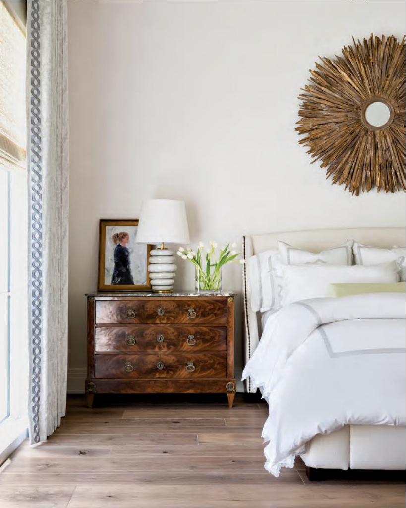 Luxe Interiors + Design Houston - Starting Fresh - An antique French commode from Memorial Antiques & Interiors—topped with Kelly Wearstler’s Phoebe Stacked table lamp for Circa Lighting—imparts warmth in the main bedroom. Custom Matouk linens from Longoria Collection dress the bed.